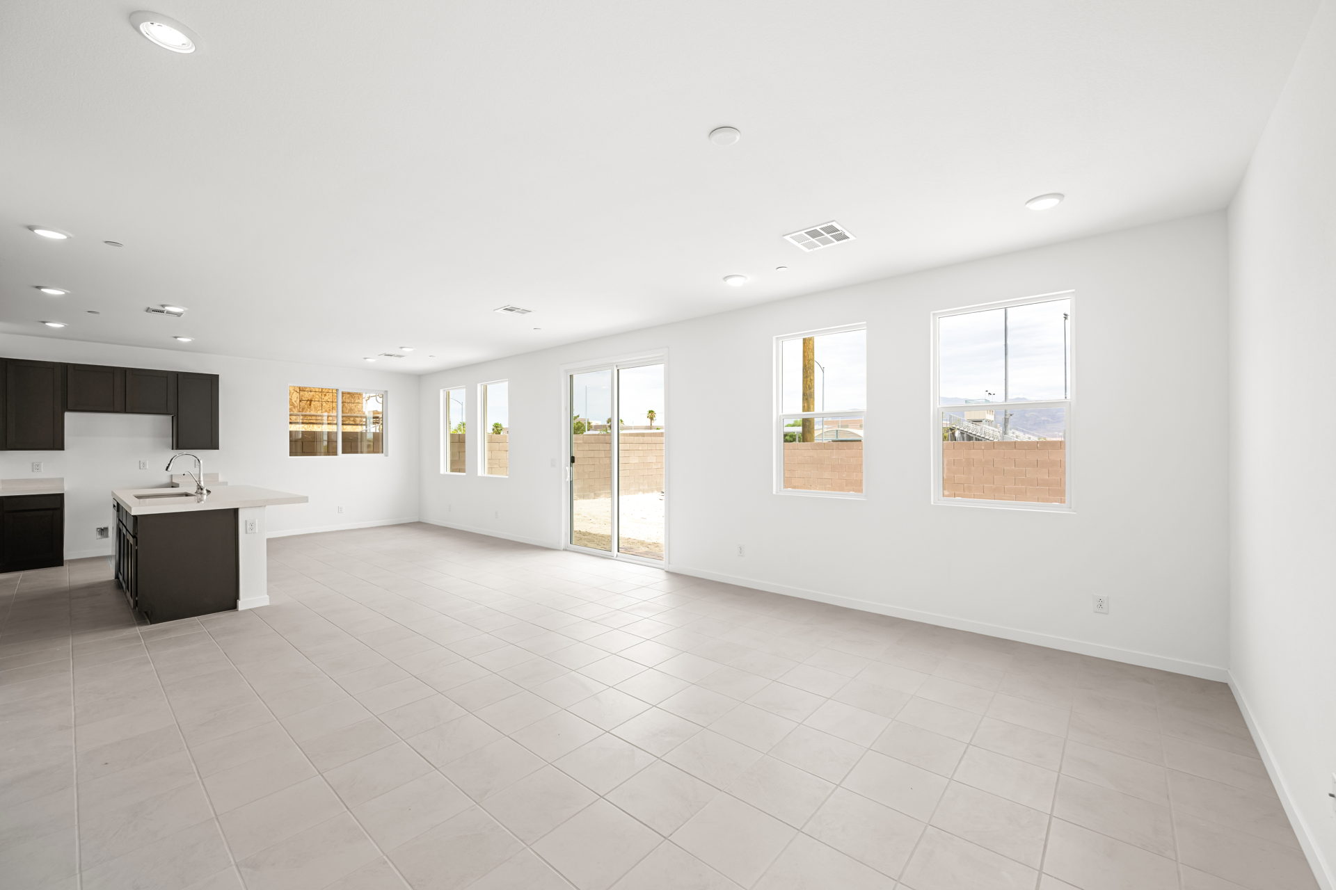 A large white room with a tile floor and a counter.