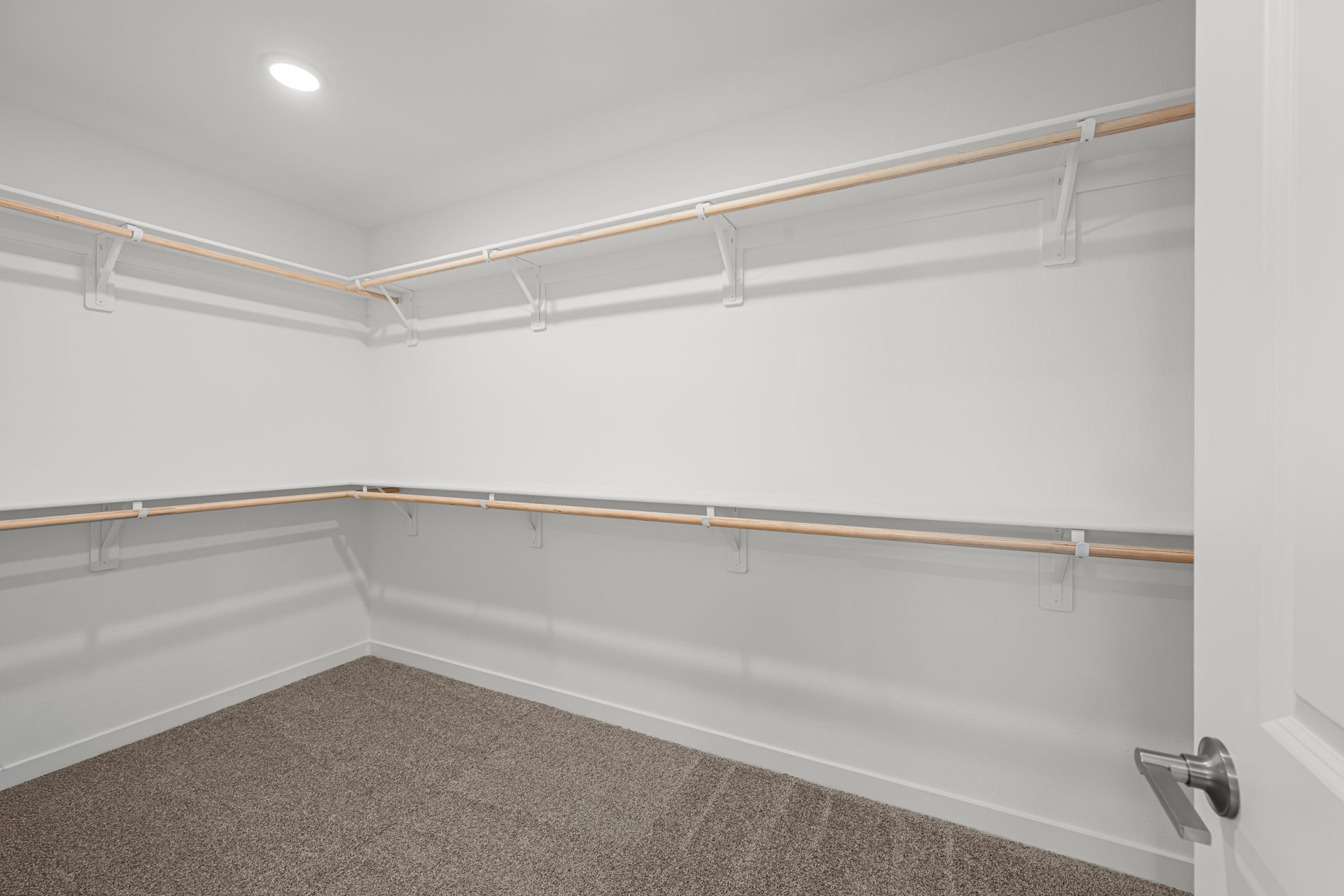 A white wall with a metal bar.