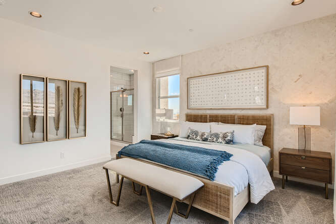 A bedroom with a bed and a bench.