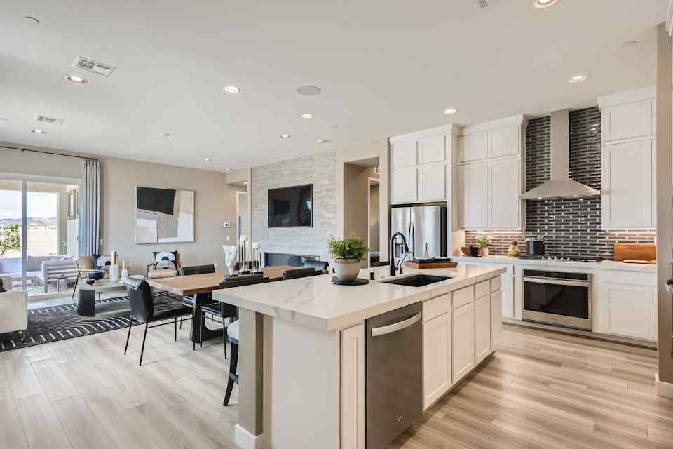 A kitchen with a bar and chairs.