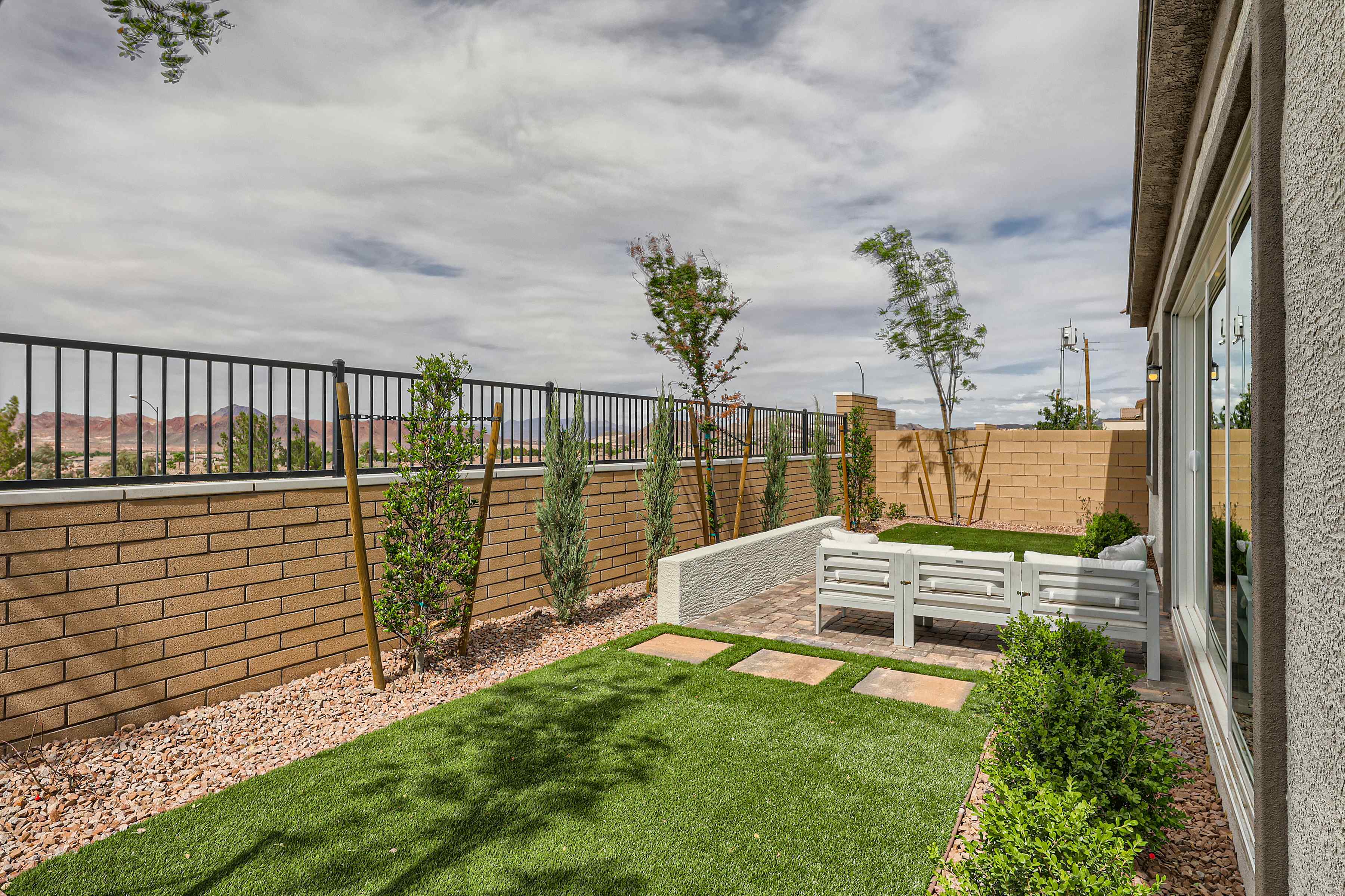 A backyard with a fence and a brick wall.