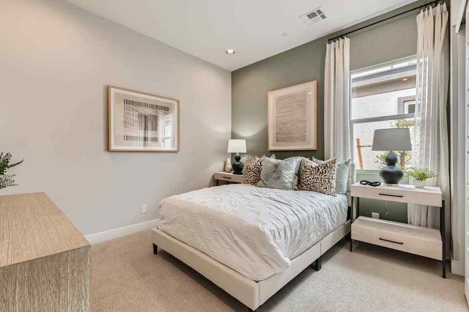 A bedroom with a bed and a lamp.