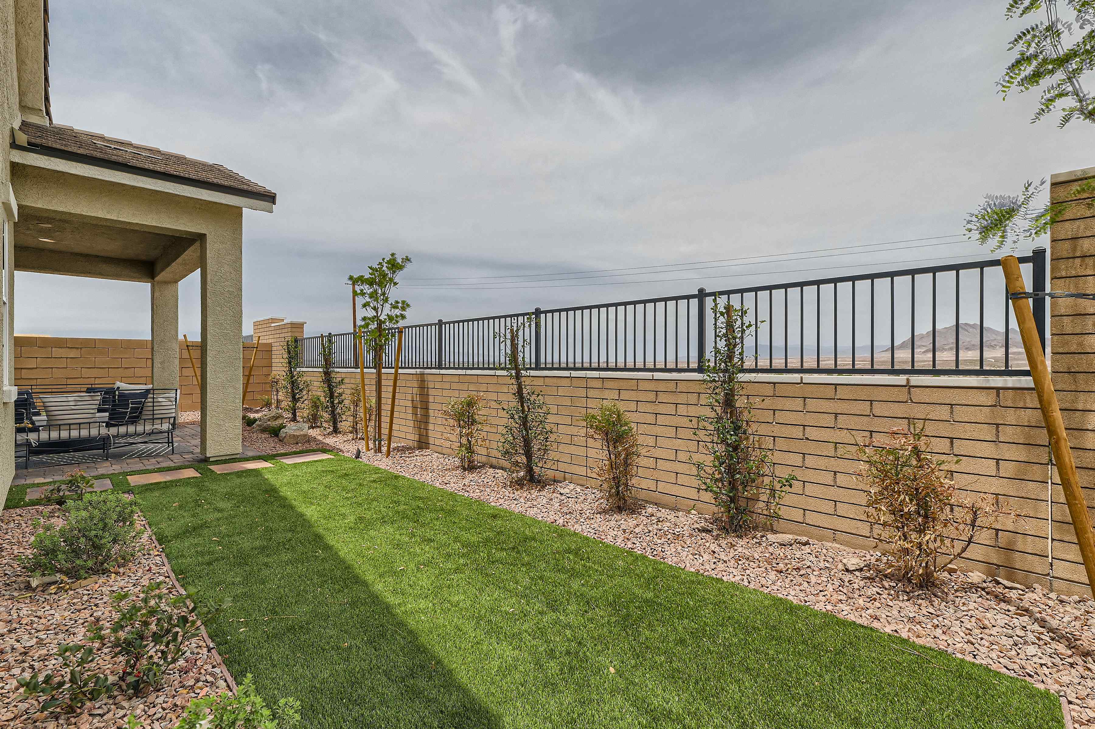A fenced in yard with a body of water in the background.