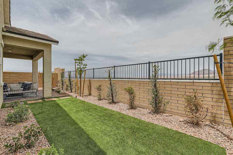 A fenced in yard with a body of water in the background.