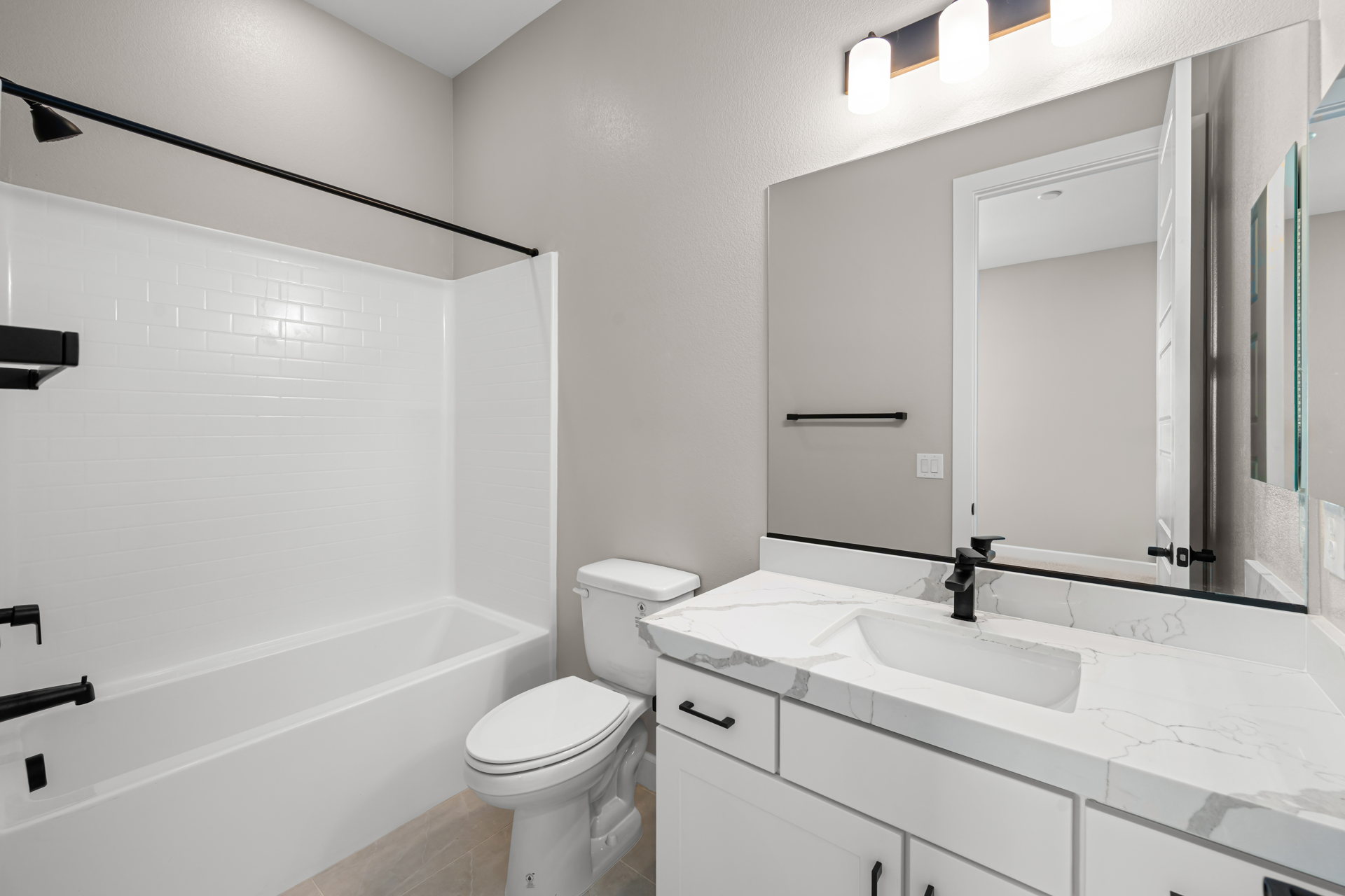 A bathroom with a tub sink and toilet.