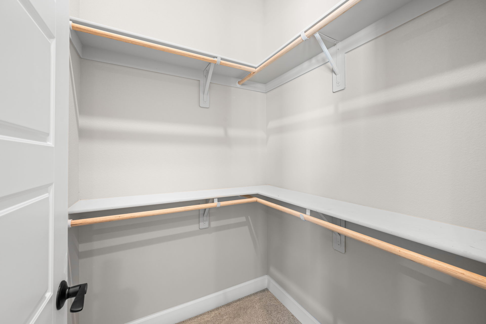 A white wall with a metal bar.