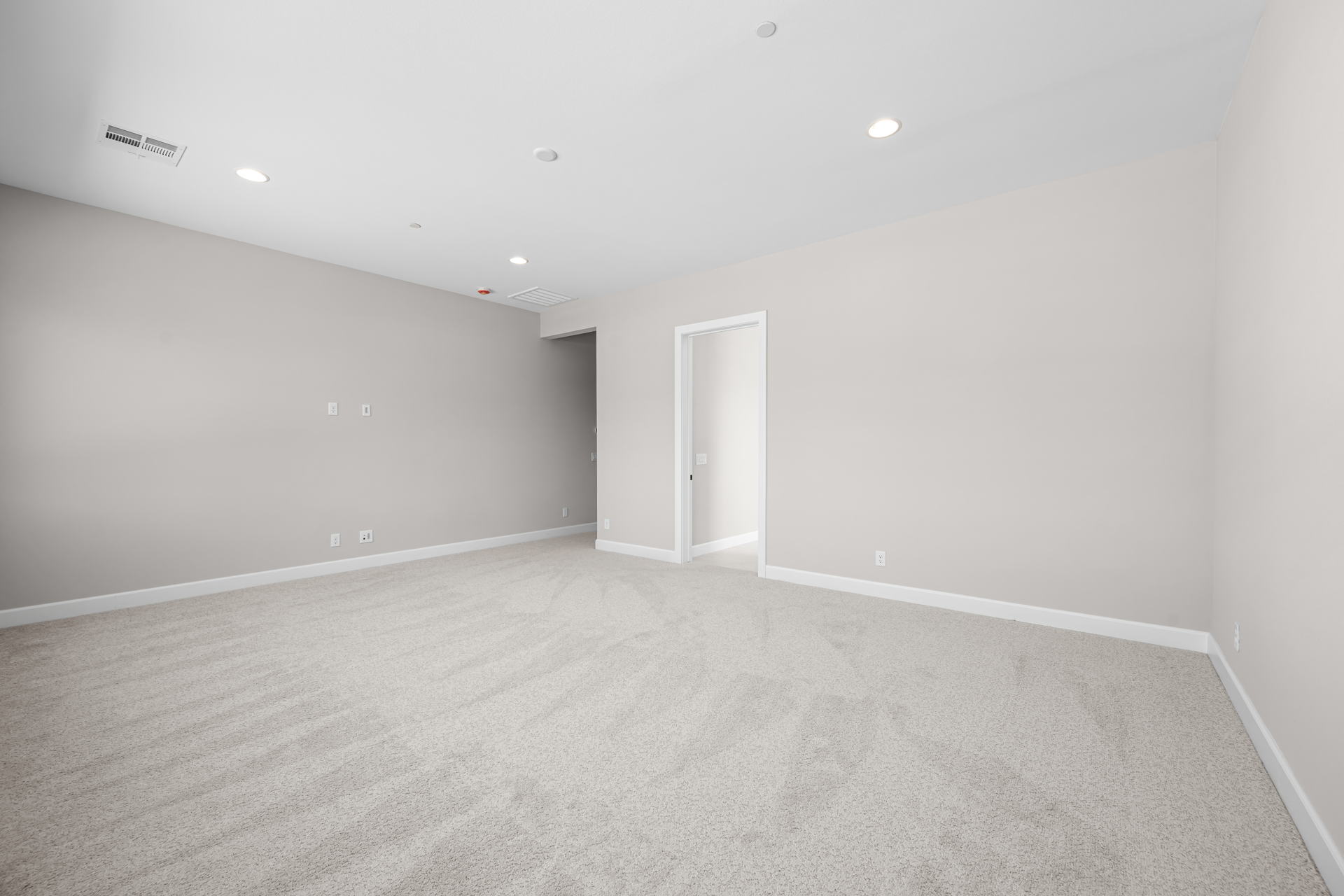 A room with a carpet and a door.