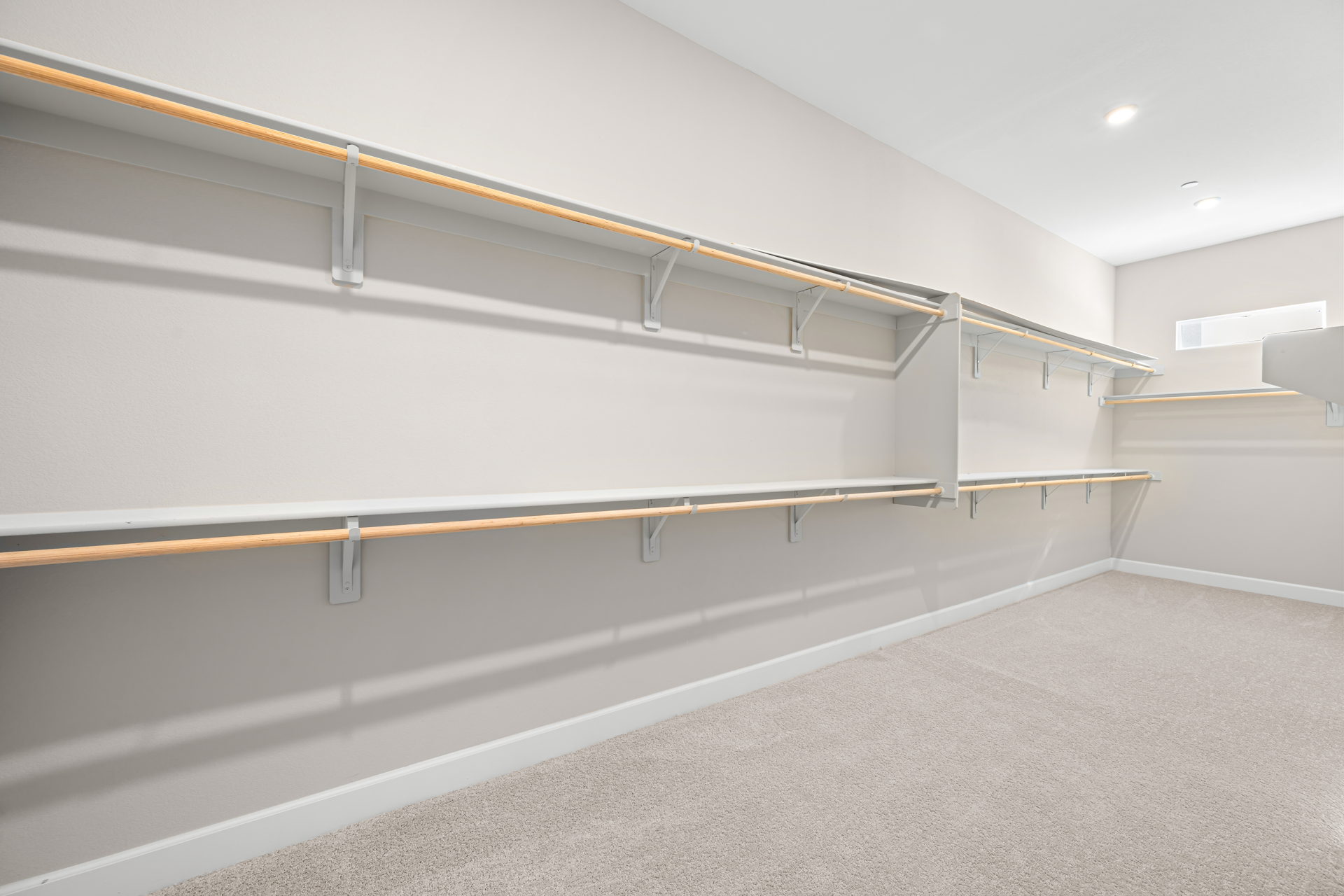 A white wall with a metal bar.