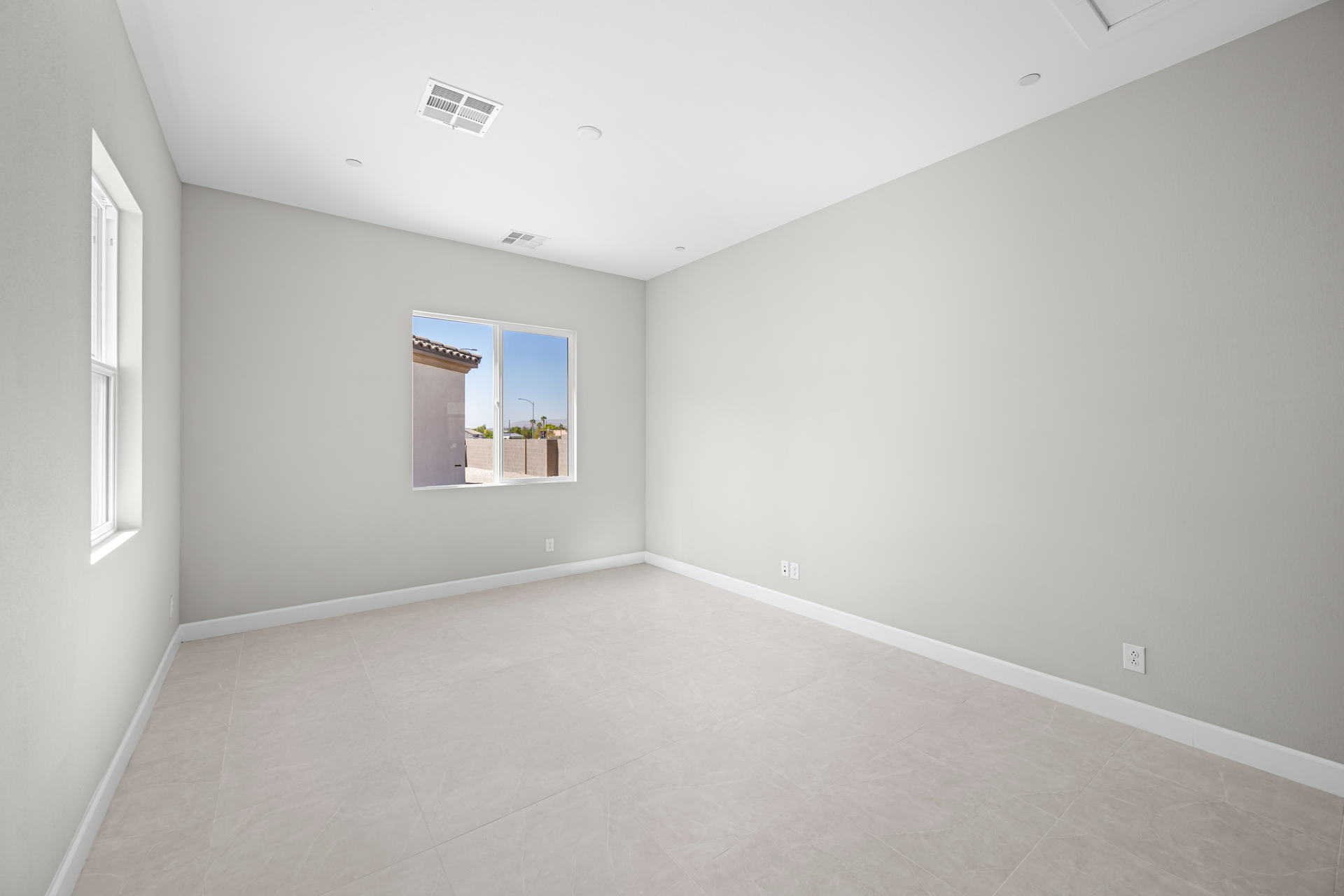 A room with a window and a white wall.
