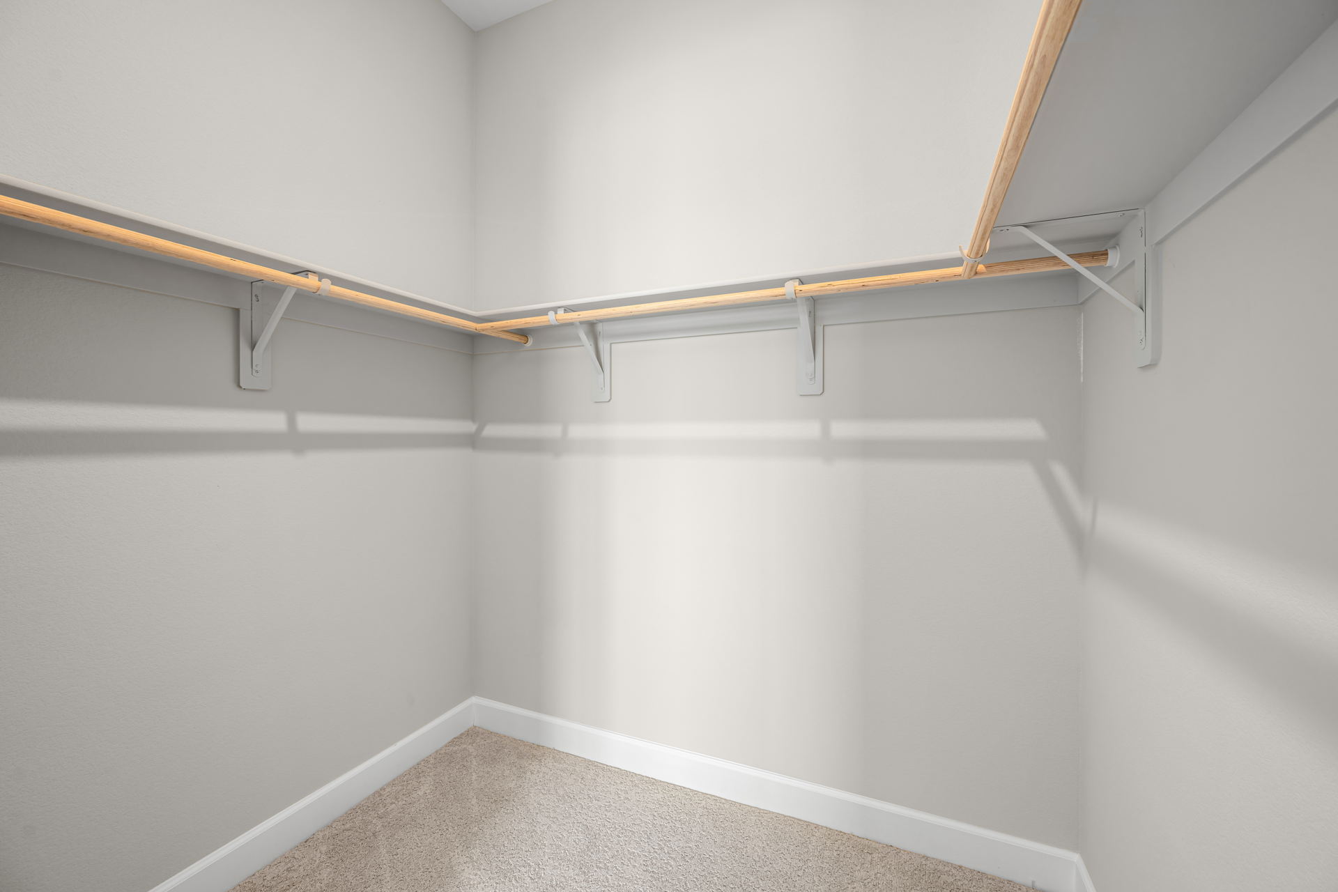 A white wall with a metal bar.