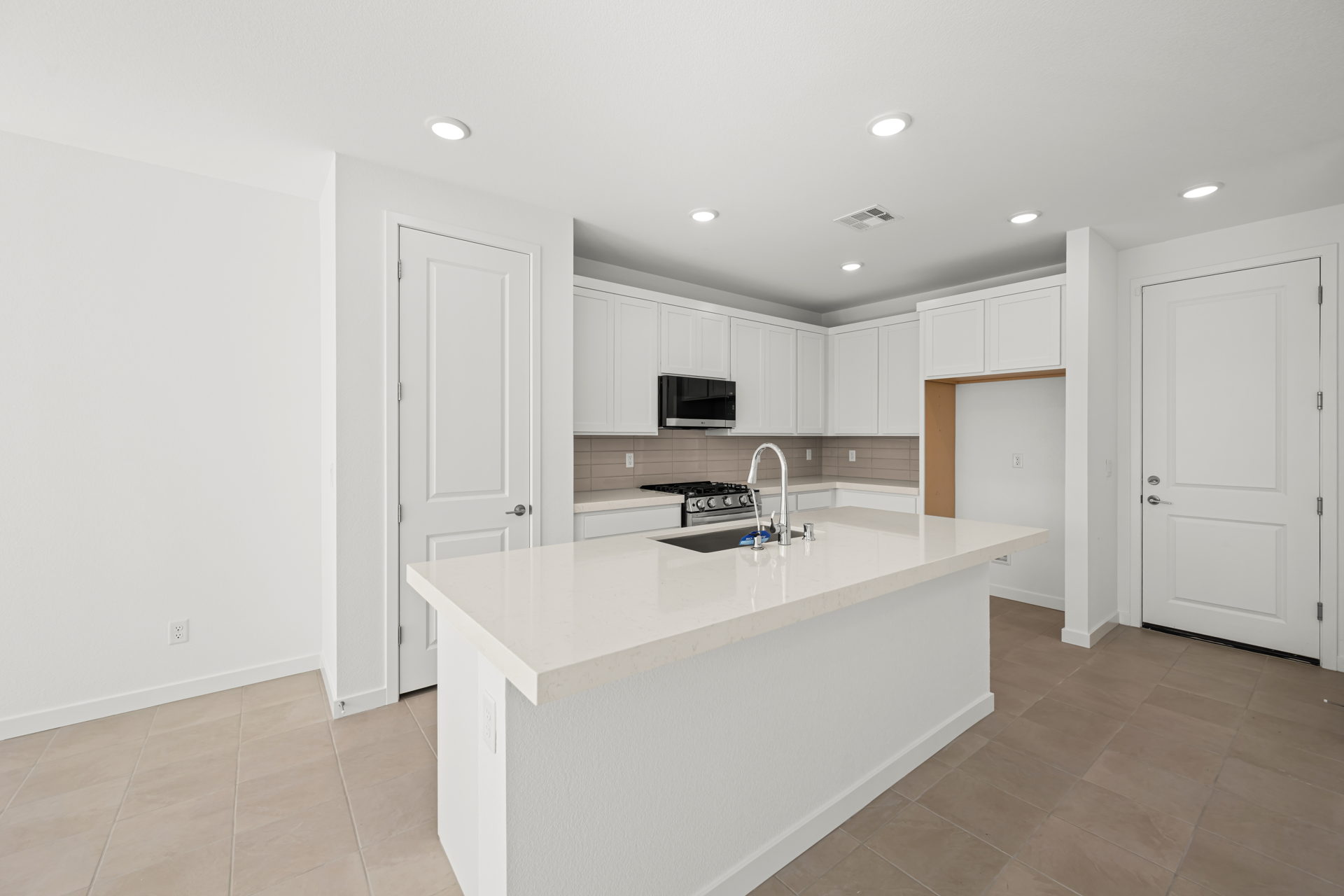 A kitchen with white cabinets.