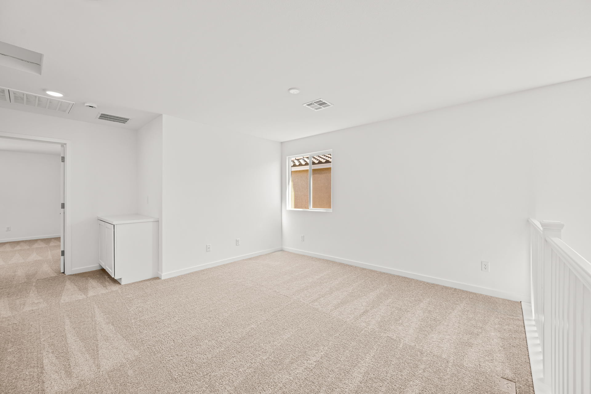 A room with a carpet and a window.