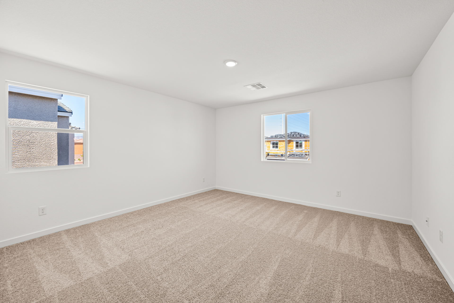 A room with a carpet and windows.