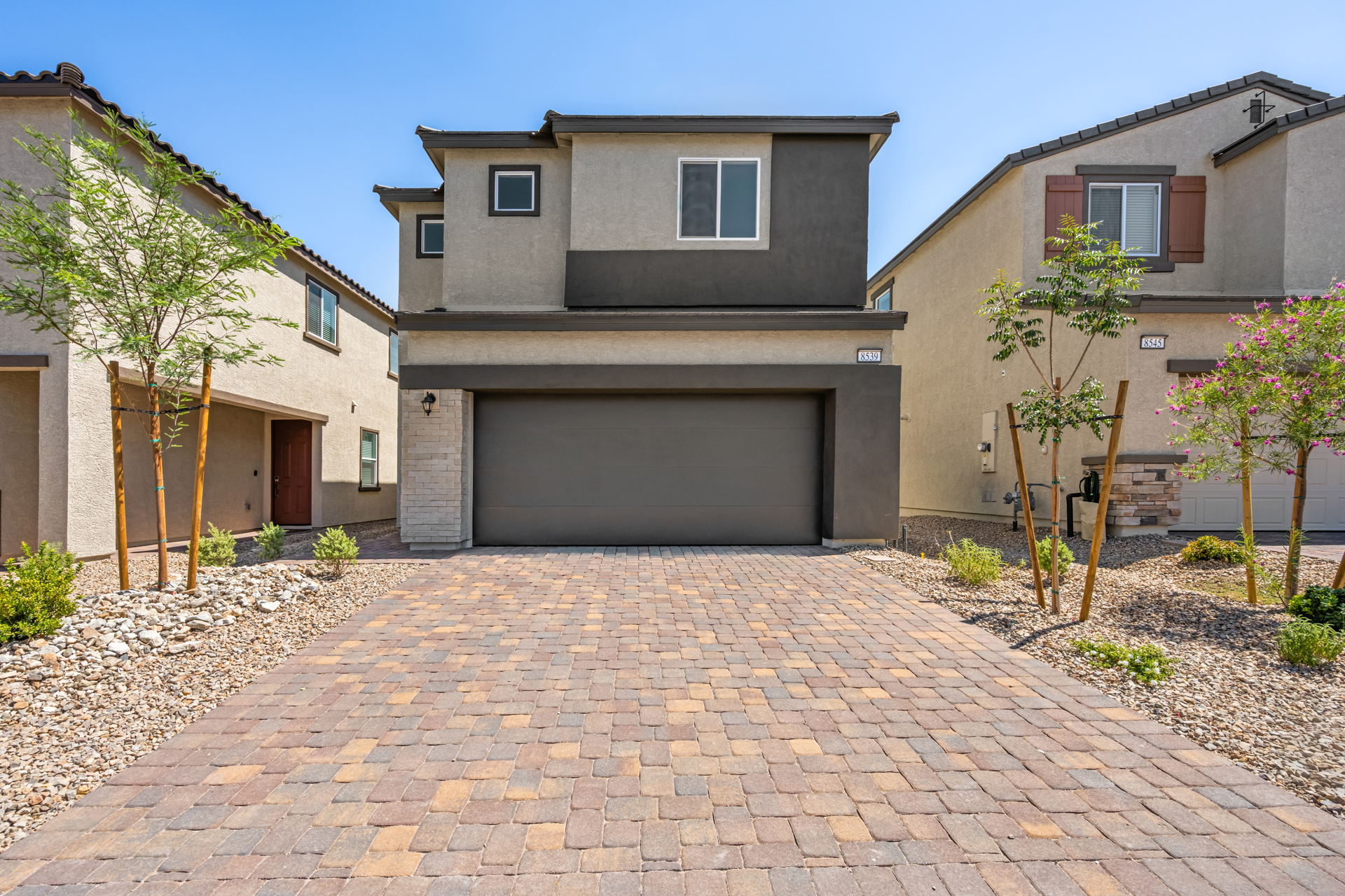 A brick driveway leading to a house.
