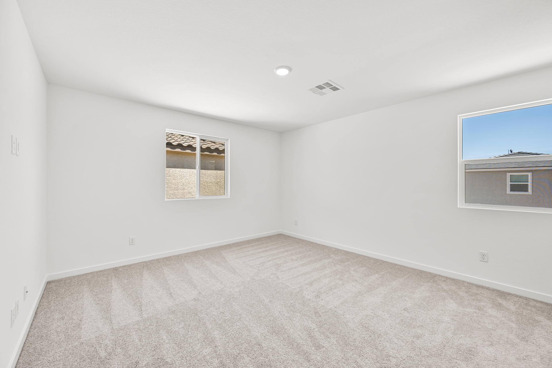 A room with a carpet and windows.