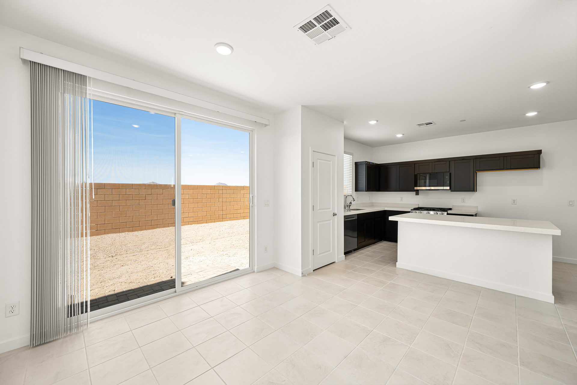 A large white kitchen with a large glass door.