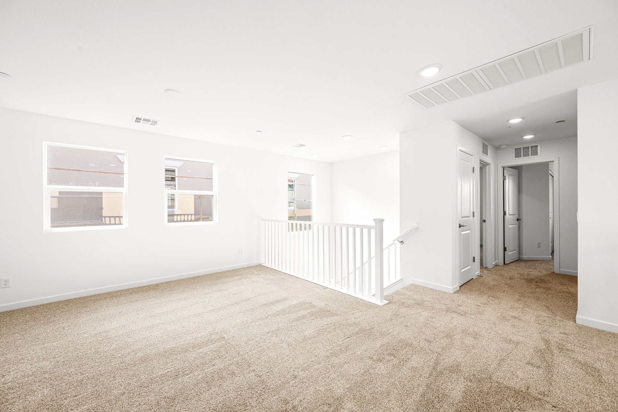 A room with white walls and a white railing.