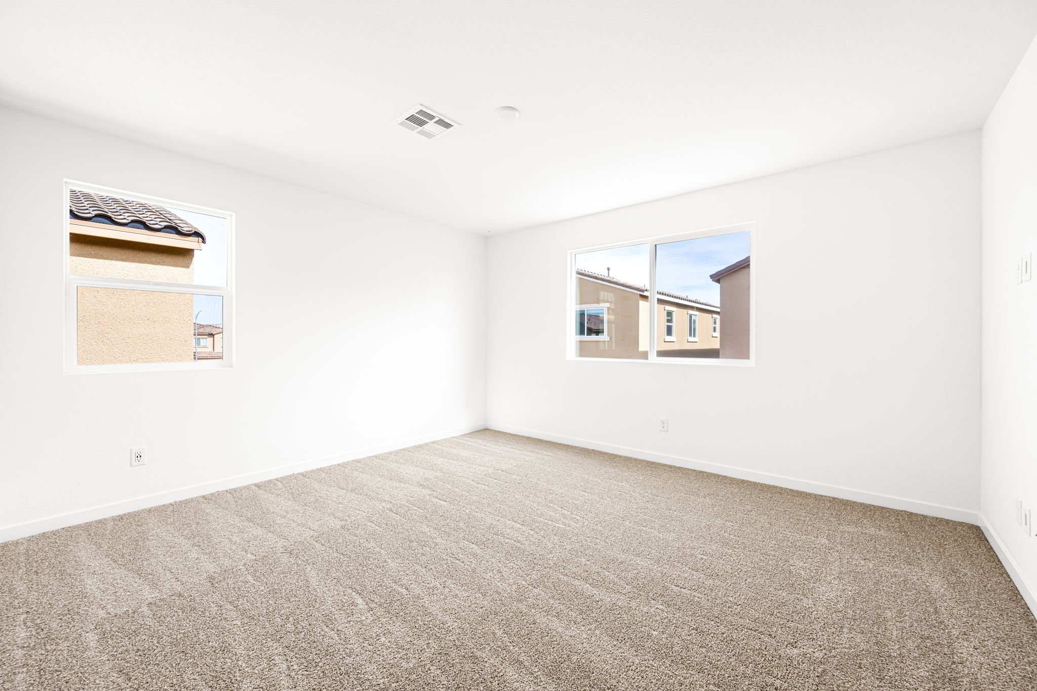 A room with a carpet and windows.