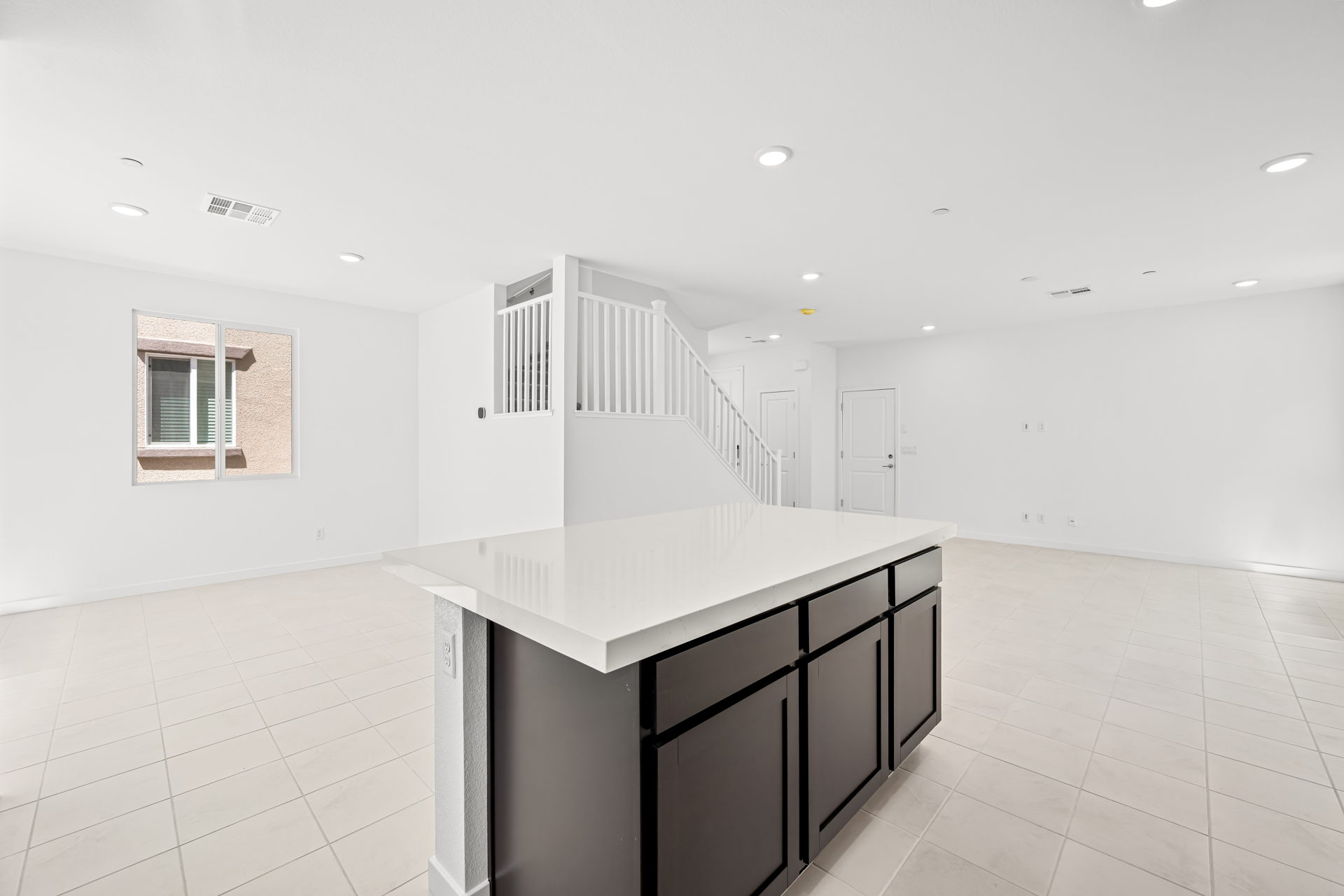 A large white room with a white table and a white staircase.