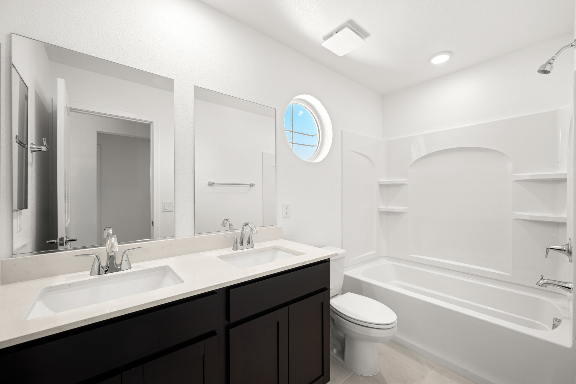 A bathroom with a tub sink and mirror.