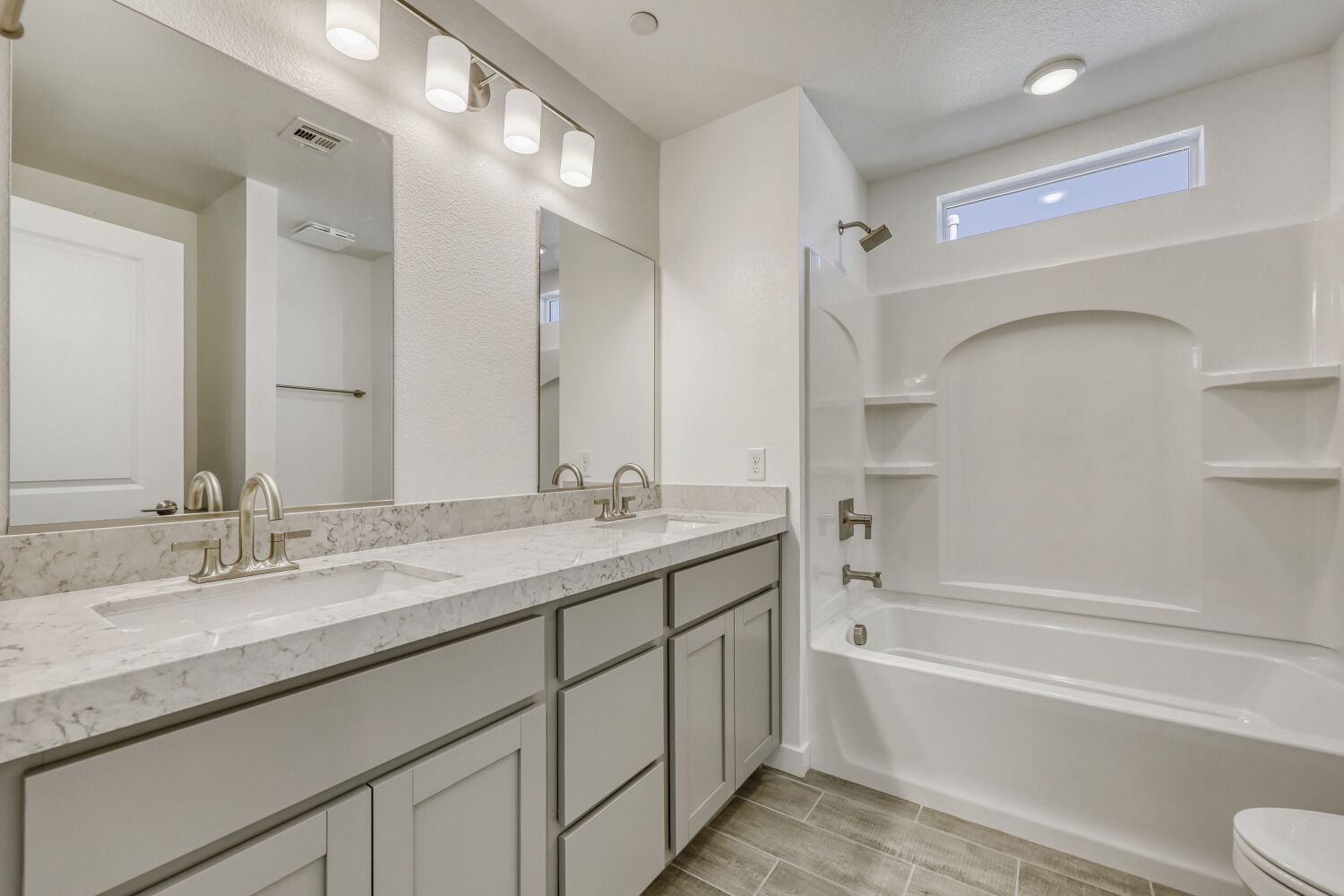 A bathroom with a tub sink and mirror.
