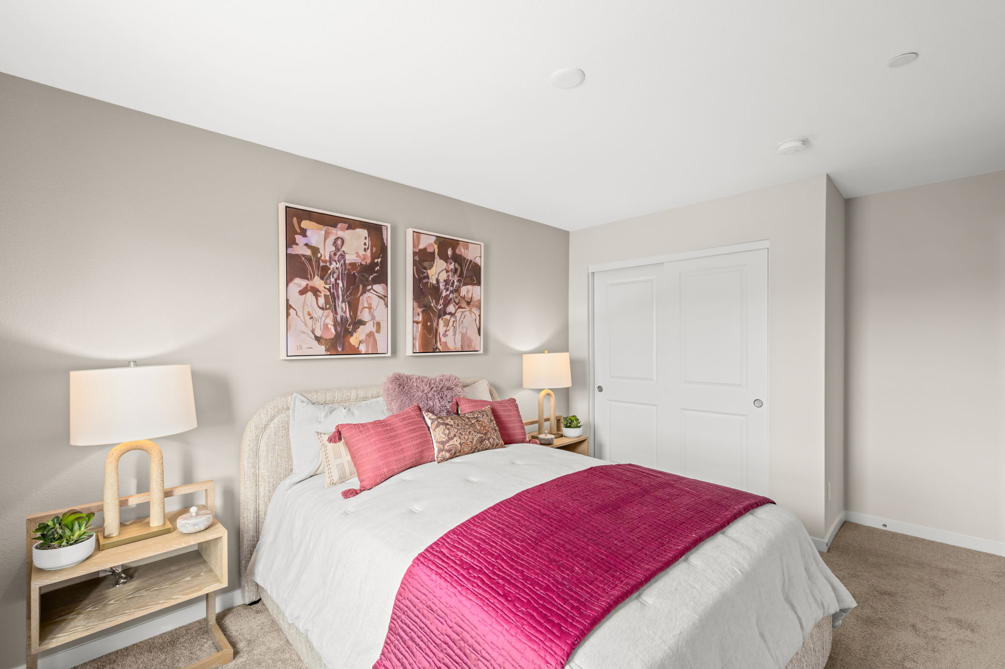 A bedroom with a bed and lamps.