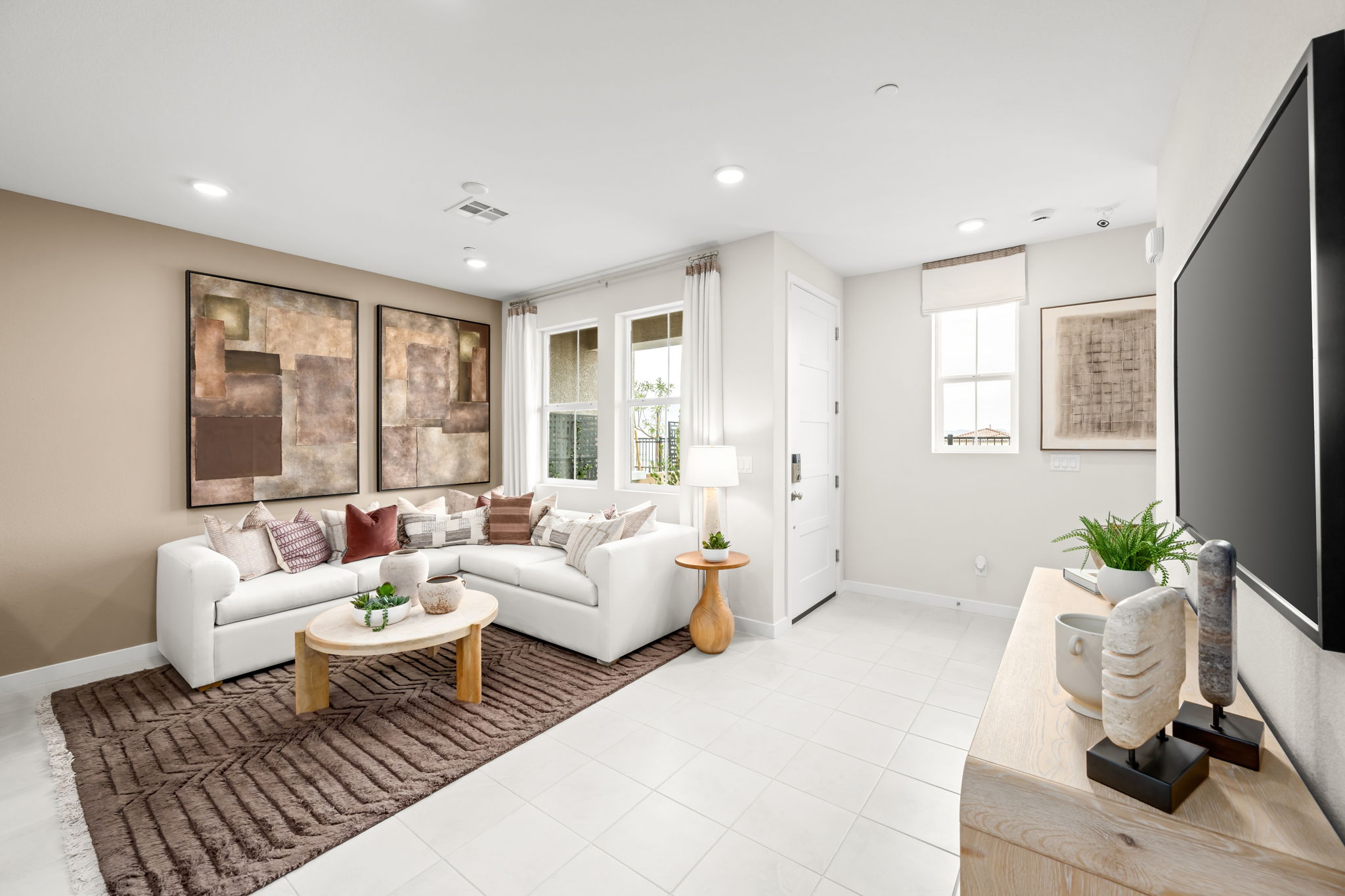 A living room with a white couch and a tv.