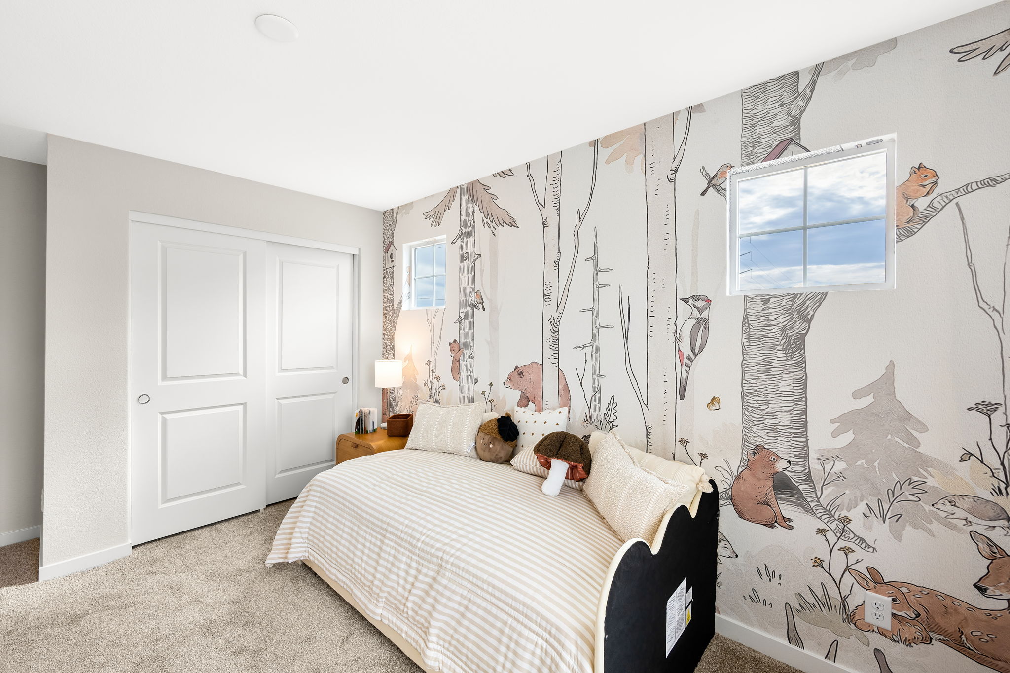 A bedroom with a bed and a wall with art on it.