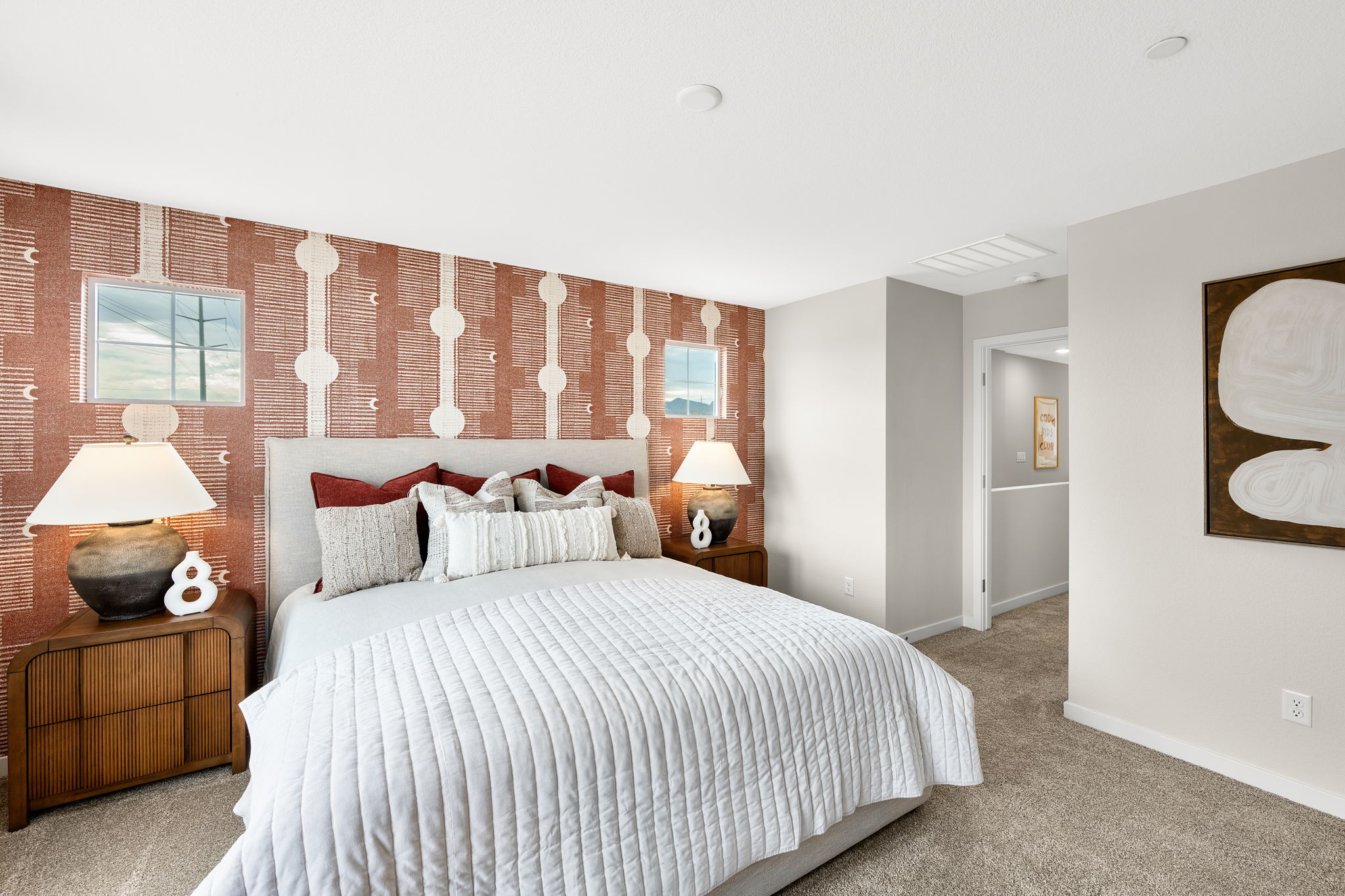 A bedroom with a bed and lamps.