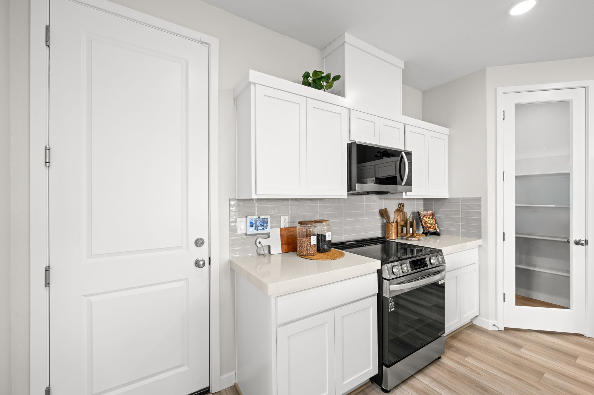 A kitchen with white cabinets.