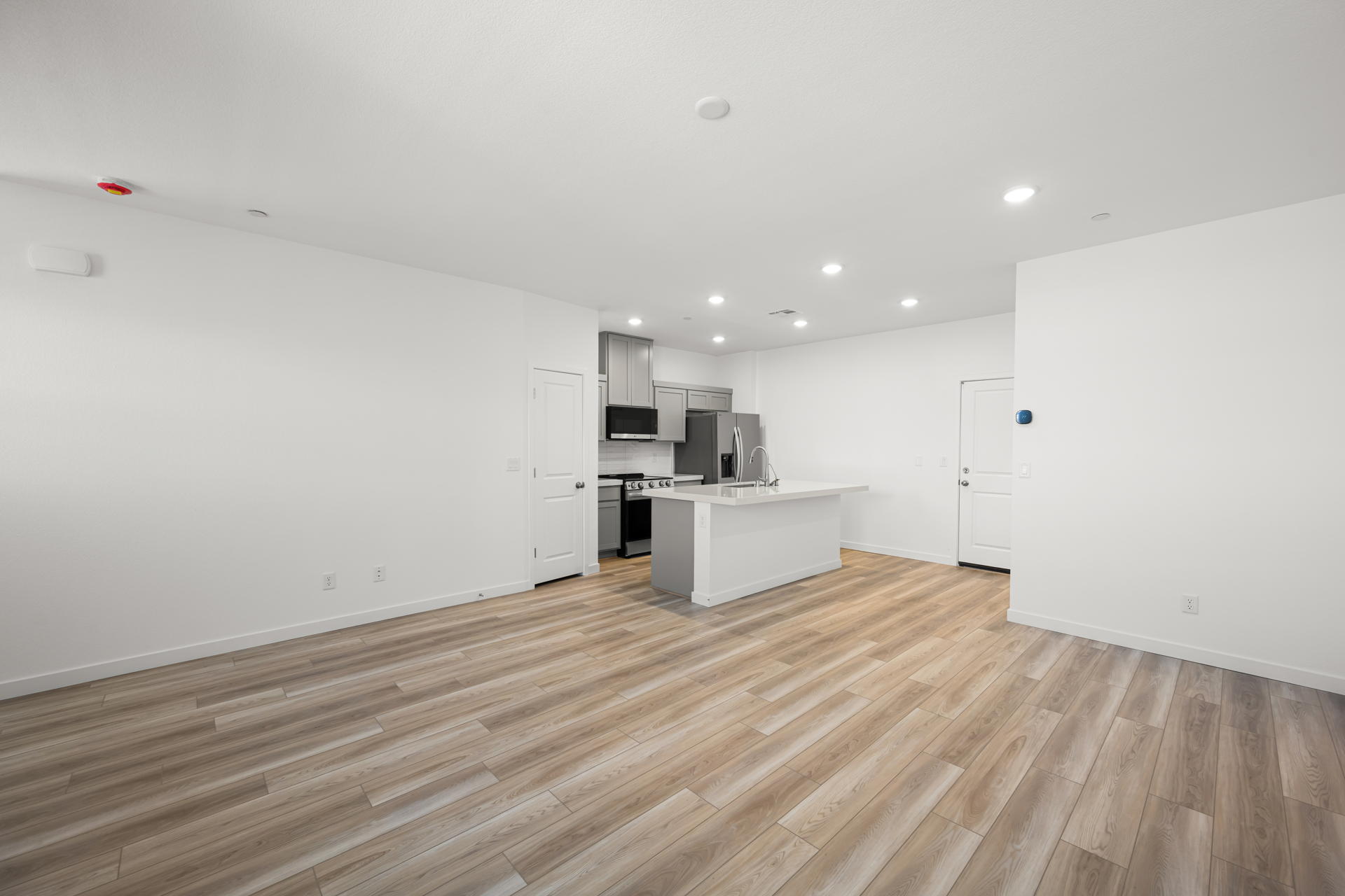 A room with white walls and wood floors.