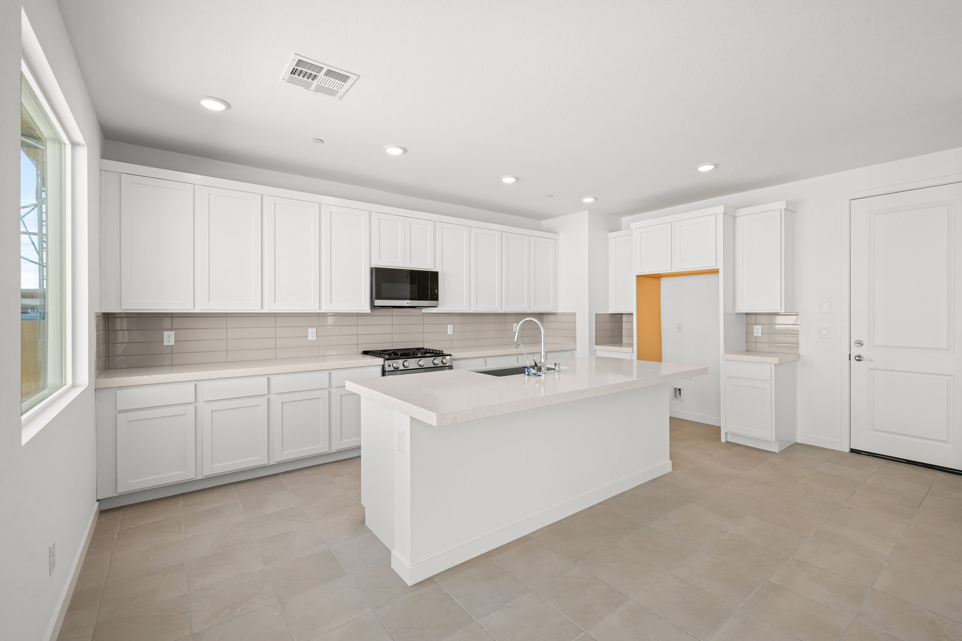 A kitchen with white cabinets.