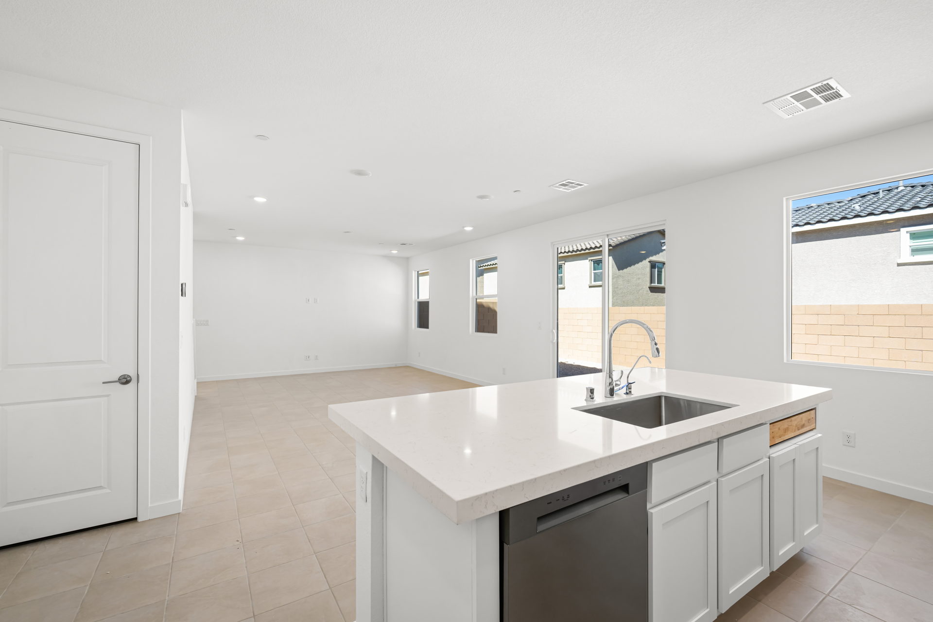 A large white kitchen with a marble countertop.