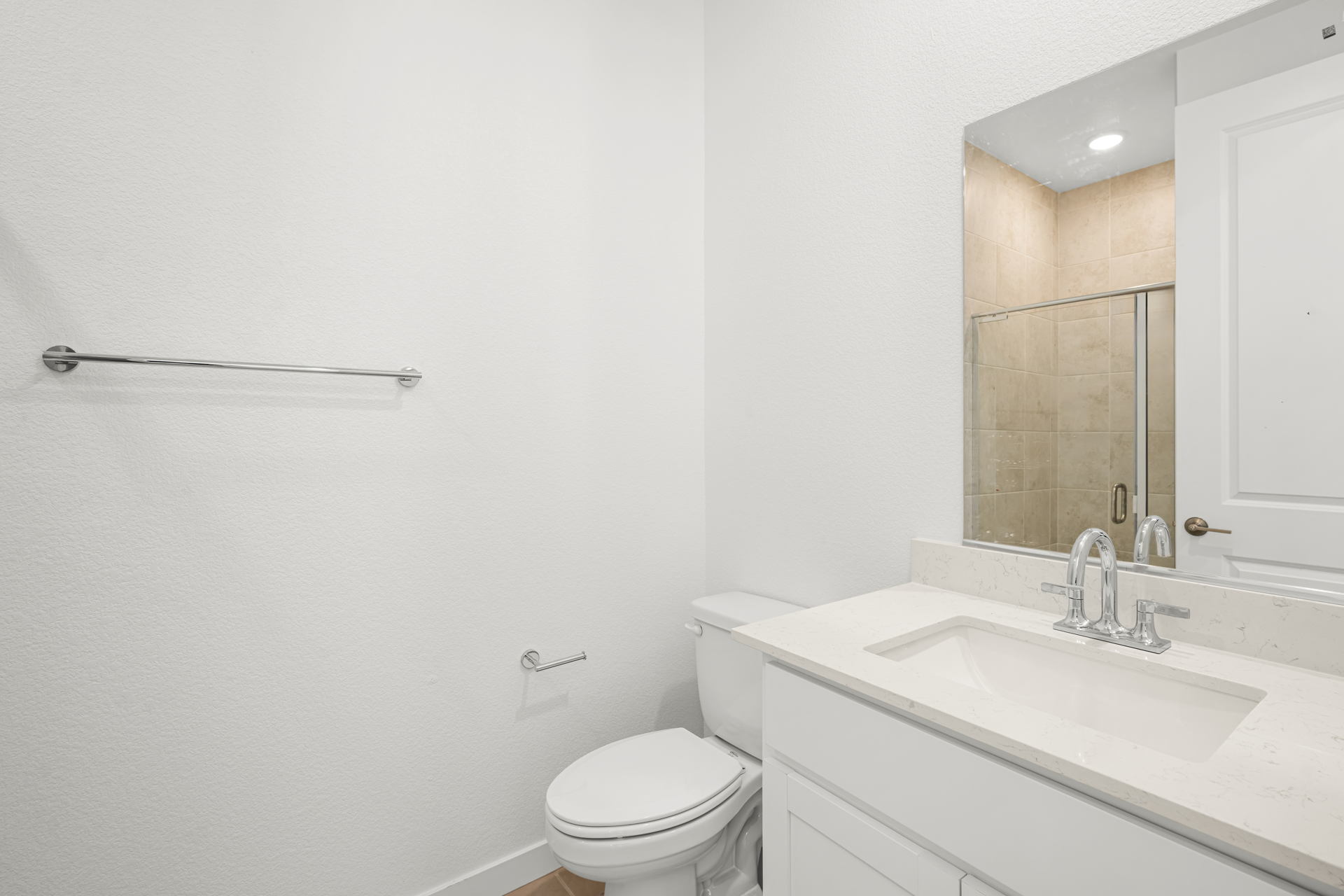 A bathroom with a sink toilet and mirror.