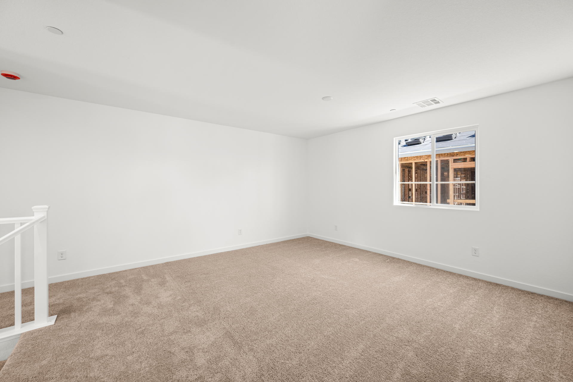 A room with a carpet and a window.