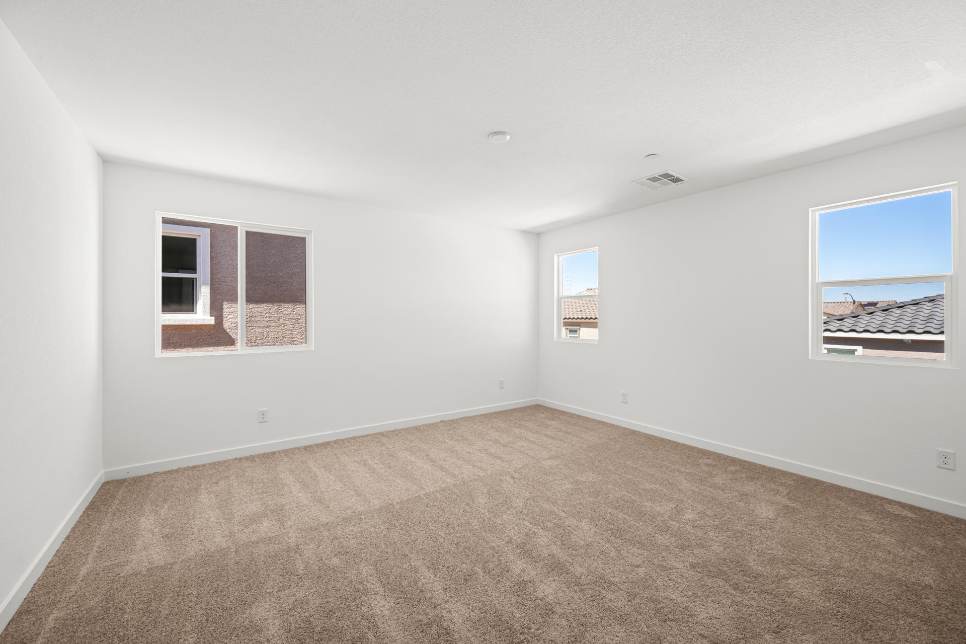 A room with a carpet and windows.