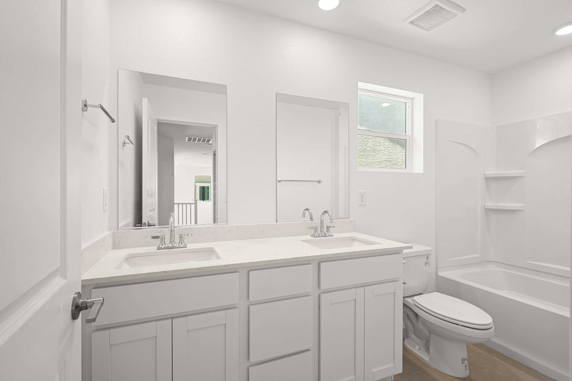 A bathroom with white cabinets.