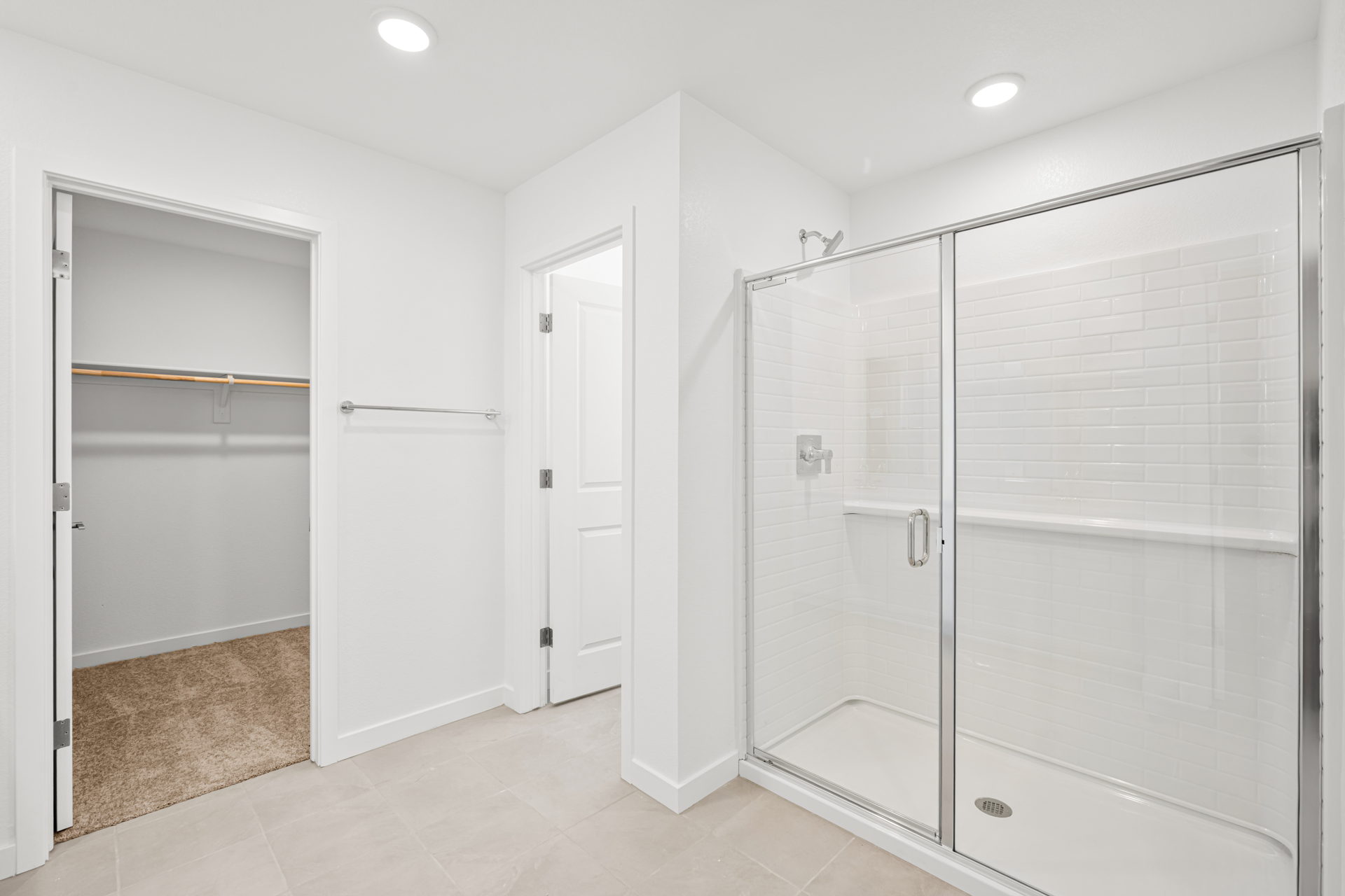 A bathroom with a shower unit and a glass door.