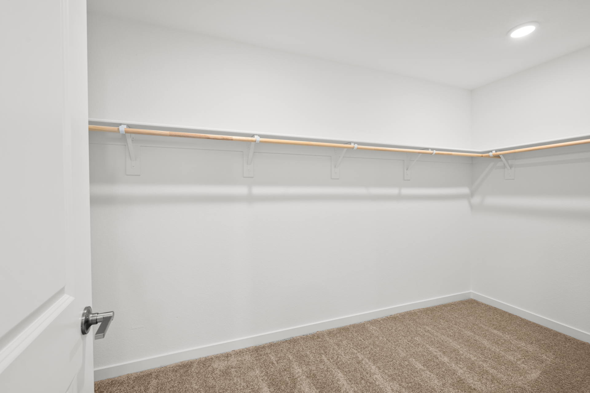 A white wall with a metal bar.