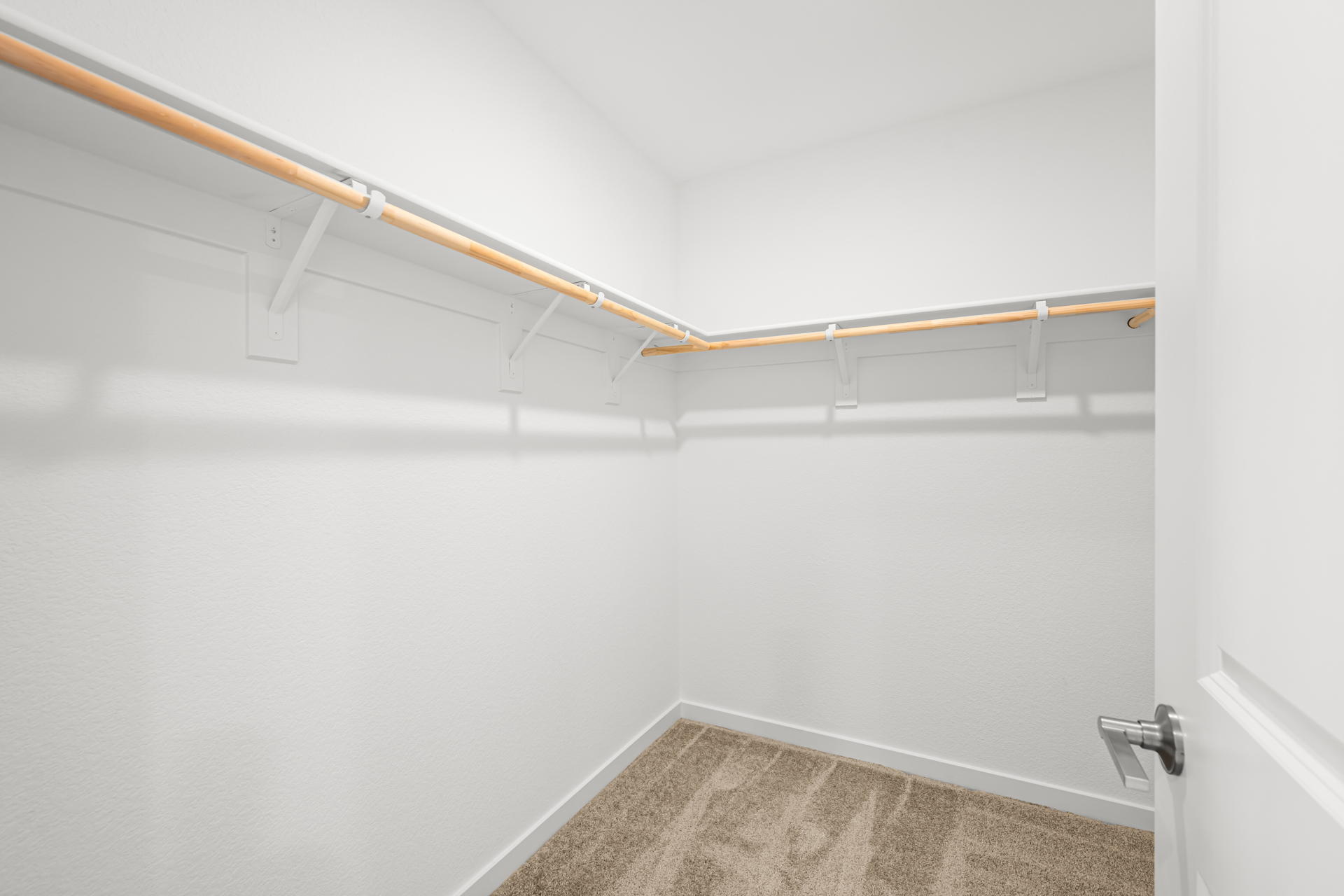 A white wall with a metal bar.