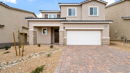 A brick driveway leading to a house.