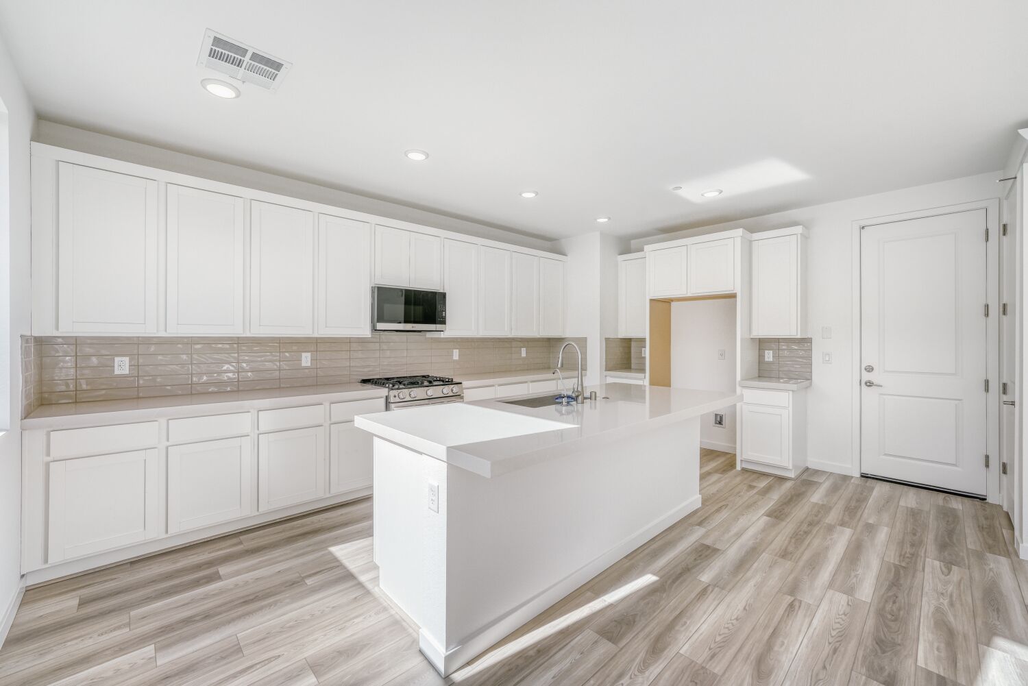 A kitchen with white cabinets.