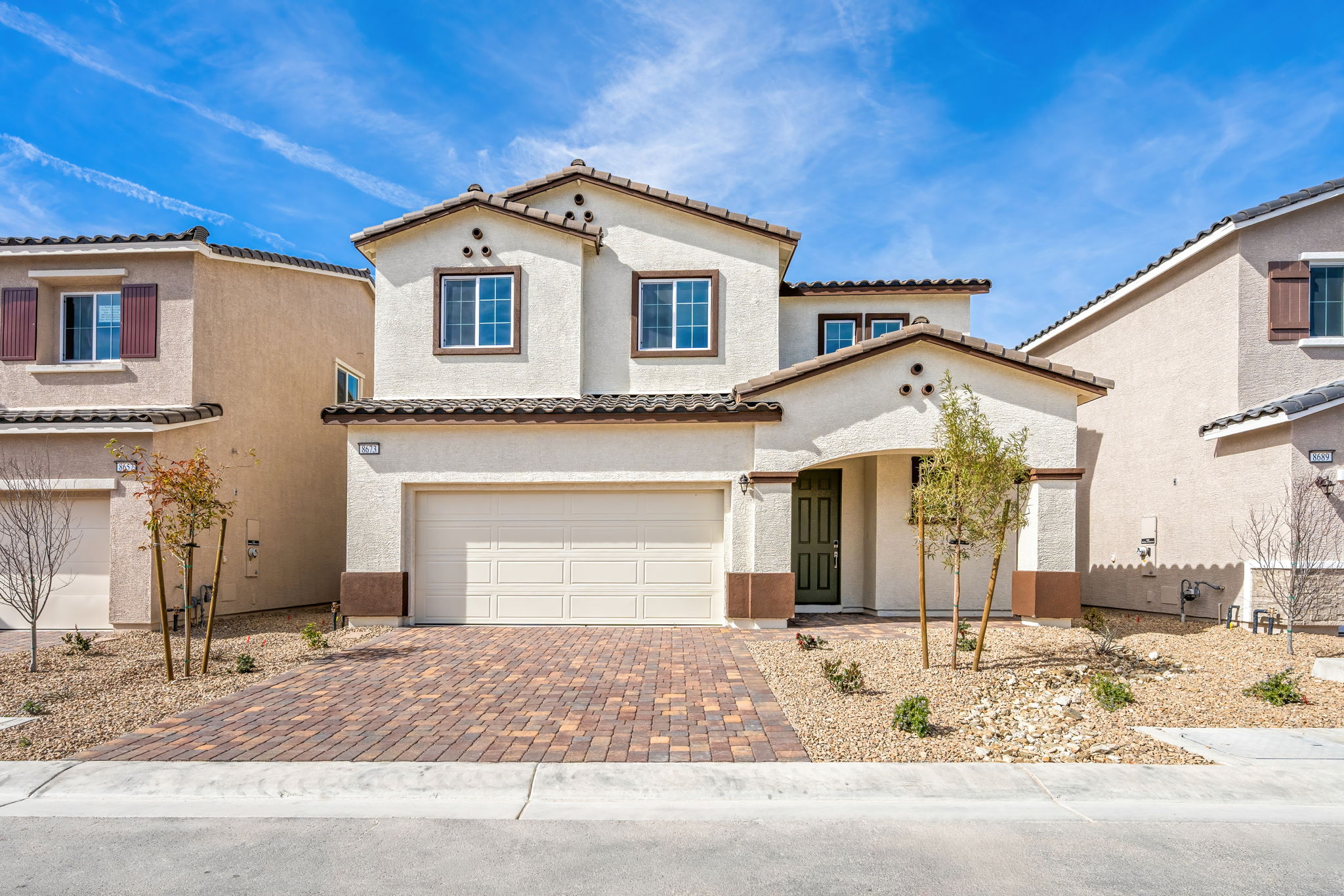 A building with a garage and trees.