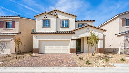 A building with a garage and trees.