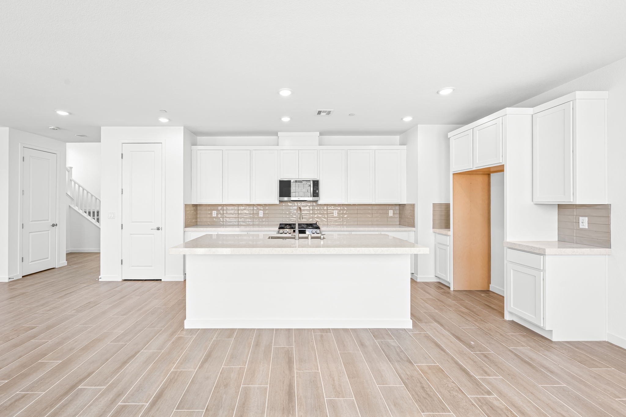 A kitchen with white cabinets.