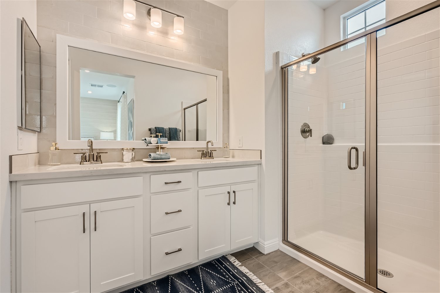 A bathroom with white cabinets.