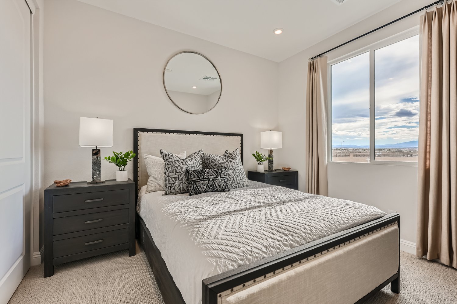 A bedroom with a large window.