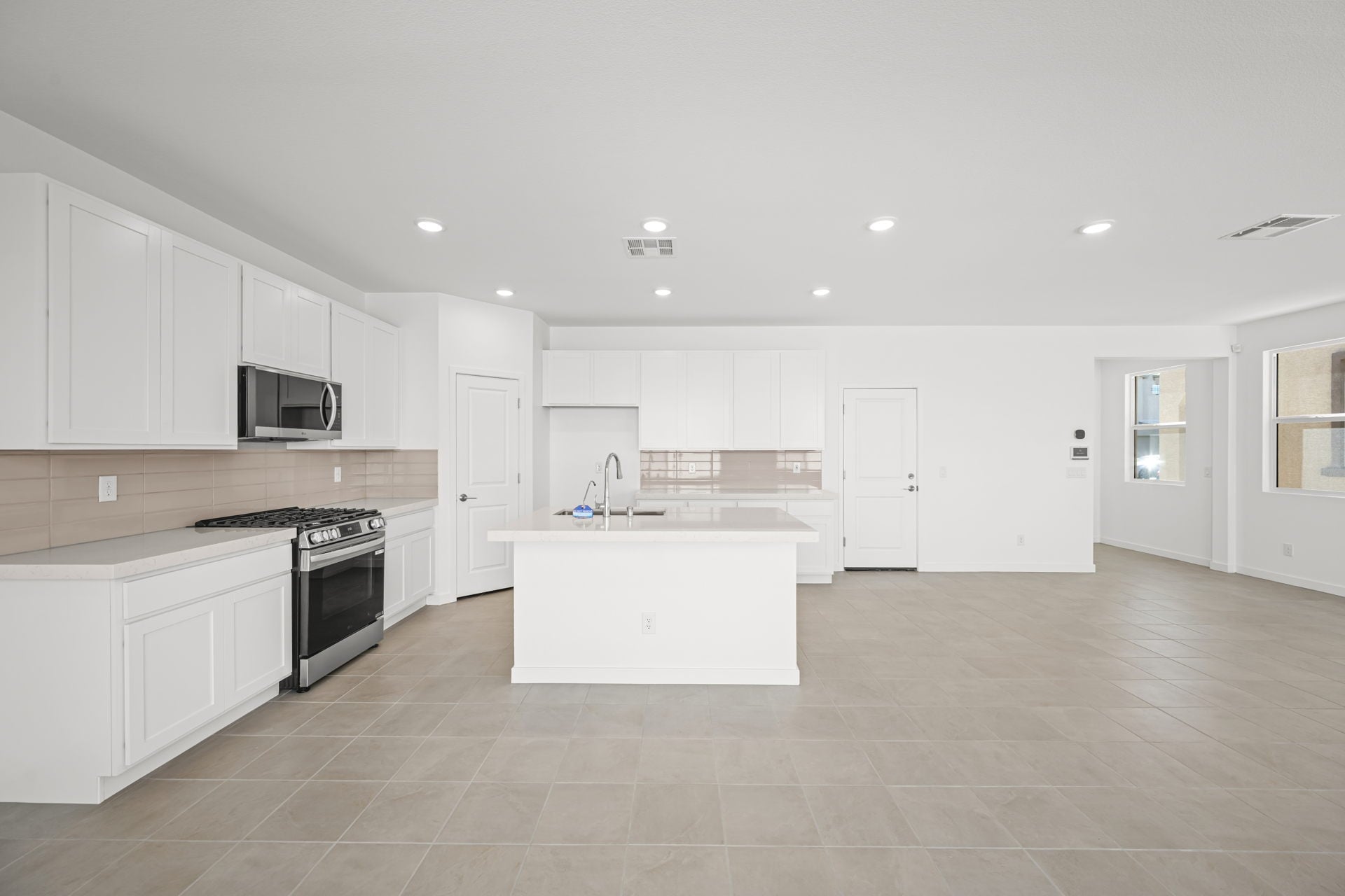 A kitchen with white cabinets.