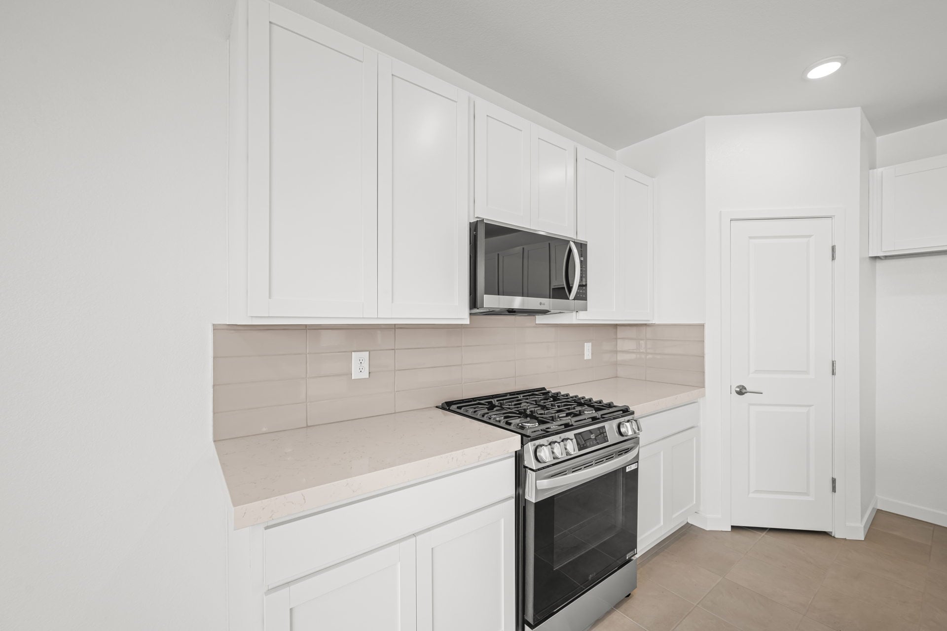 A kitchen with white cabinets.