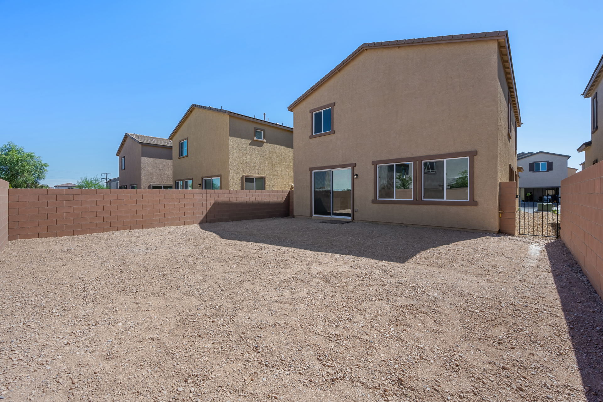 A dirt driveway leading to a house.